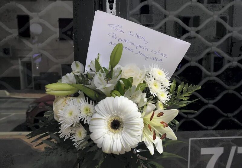 Photo d'une gerbe de fleurs blanches avec un mot en hommage à la victime. ABJ ⁄ NICE MATIN⁄MAXPPP.jpg