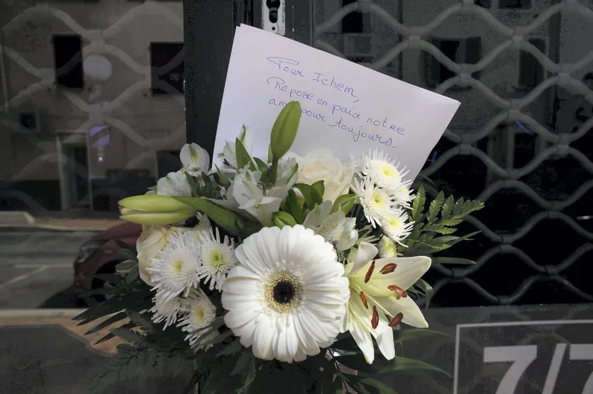 Photo d'une gerbe de fleurs blanches avec un mot en hommage à la victime. ABJ ⁄ NICE MATIN⁄MAXPPP.jpg