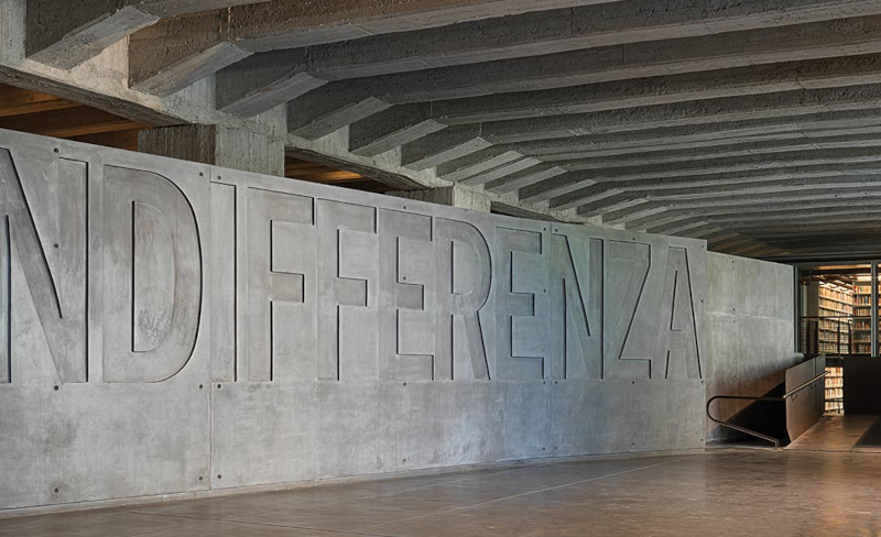 Le hall d'entrée du mémorial de la Shoah à Milan avec le mur sur lequel est gravé en très grandes lettres "INDIFFERENZA" l'indifférence qui permet au mal de s'installer. Photo © Matteo Piazza